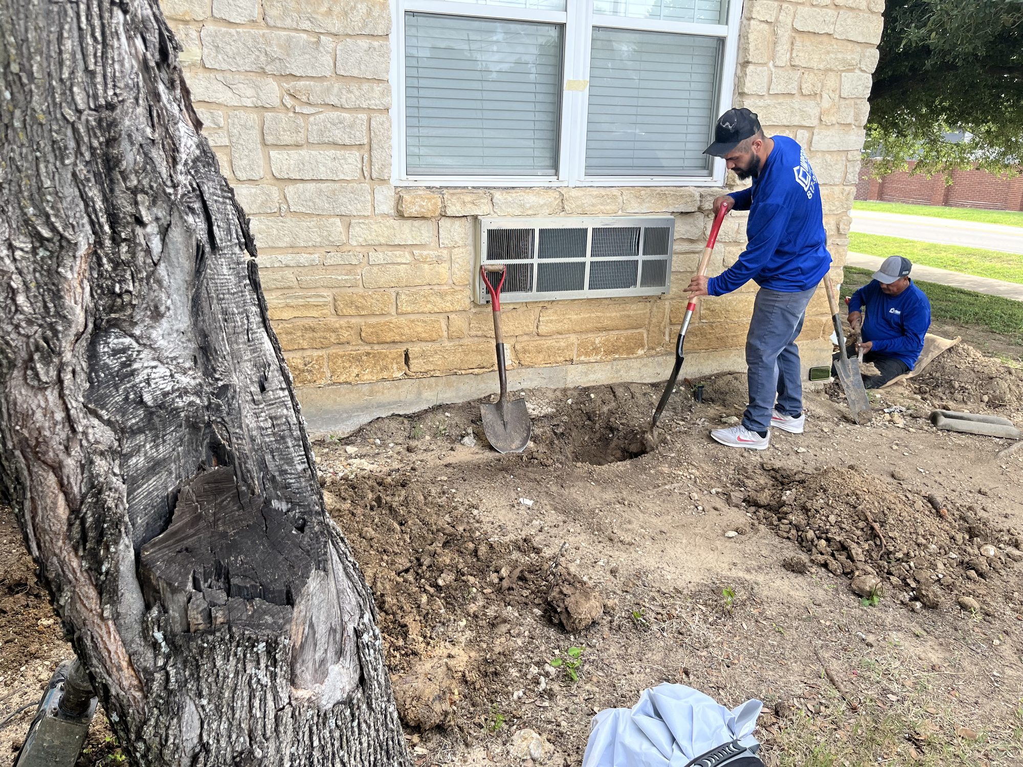 Crew digging limestone, Imperial Foundation Repair job site in North Texas