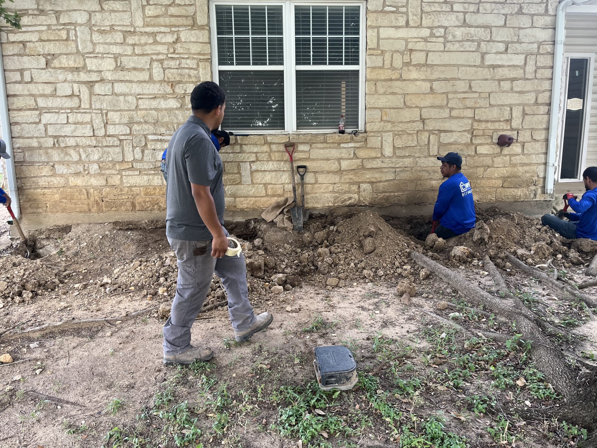 Crew excavation limestone, Imperial Foundation Repair job site in North Texas