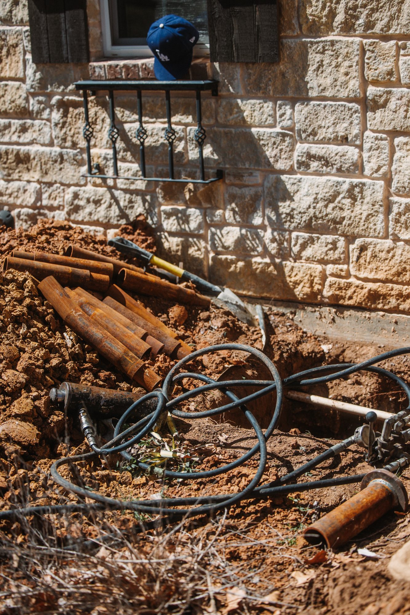 Steel piers staged with hoses, Imperial Foundation Repair job site in North Texas