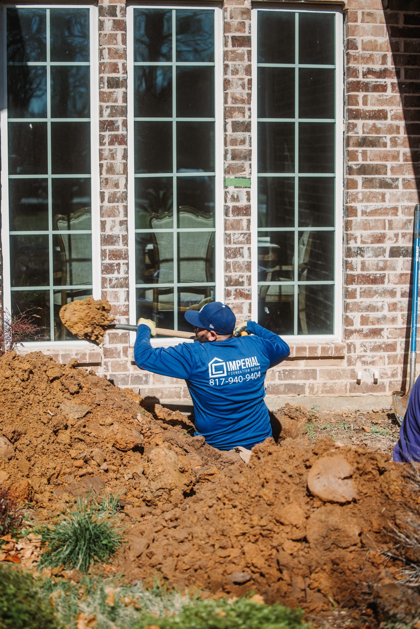 Crew in trench at window, Imperial Foundation Repair job site in North Texas